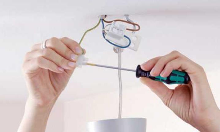 Replacing a fixture holder in the lamp with his hands